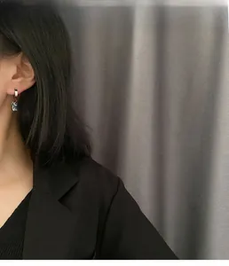 Detailansicht der silbernen Hasenohrringe mit klarem Edelstein am Model getragen