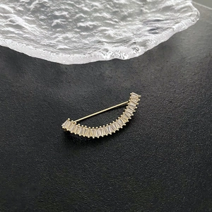 Élégante broche lune dorée avec cristaux rectangulaires sur un fond noir texturé