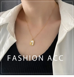 Detail of gold rabbit pendant necklace with white mother-of-pearl inlay on female model