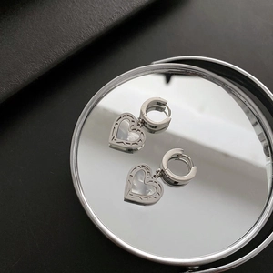 Elegante herzförmige Muschel-Ohrringe mit silberfarbenem Finish auf einem Spiegel
