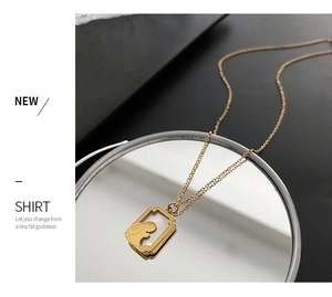 Detail of golden rabbit pendant with white mother of pearl on a sleek mirror background