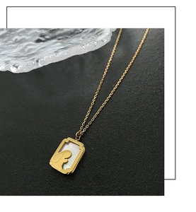 Detailed macro view of gold-plated rabbit pendant with white mother of pearl inlay