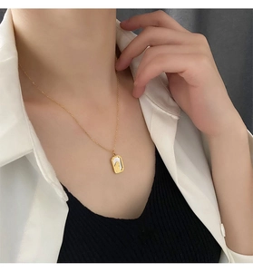 Detail of vintage French gold necklace with white mother-of-pearl rectangular pendant
