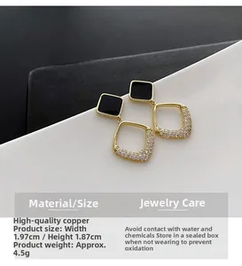 Detail view of geometric square drop earrings with black studs and pavé zircon stones