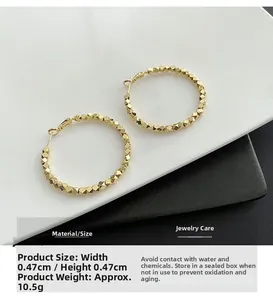 Detailed view of golden hoop earrings with multifaceted bead texture and dimensions