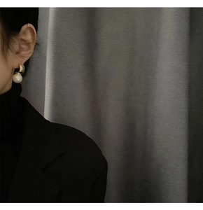 Detail of elegant S925 pearl earrings with golden curved arc on a model profile view