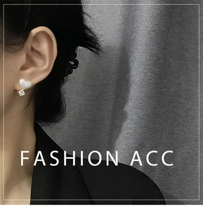 Détail de boucles d'oreilles cœur en perle avec pendentif zircon sur modèle