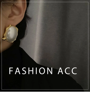 Close-up of vintage large pearl earring with irregular wavy golden metal frame