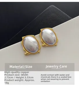 Detailed size view of oval pearl earrings with gold copper edges, 2.73x3.53cm dimensions
