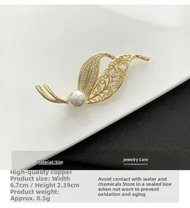 Close-up of golden leaf brooch with pearls and zircons, showing 6.7cm by 2.39cm dimensions