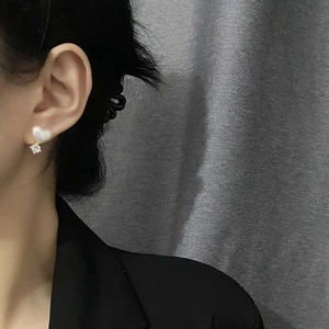 Élégantes boucles d'oreilles cœur en perles avec zircons et finition dorée sur modèle