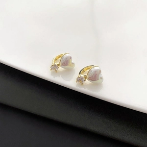 Boucles d'oreilles cœur dorées avec perles irisées et oxydes de zirconium sur fond propre