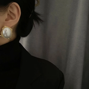 French retro style large pearl earrings with gold metal frame on a female model