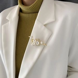 Elegant natural shell flower branch brooch with pearls and crystals on white suit lapel