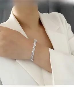 Gros plan du bracelet ouvert orné de zircons porté sur un poignet avec blazer