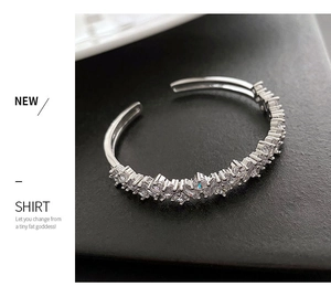 Vue détaillée d'un bracelet jonc argenté avec pierres de zircone et design ouvert ajustable