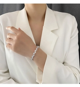 Gros plan d'un bracelet de tennis scintillant en zircon porté avec un blazer blanc élégant