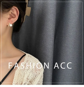 Close-up of elegant white flower stud earrings with gold frame on female model