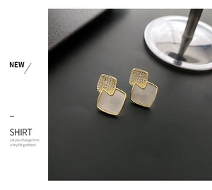 Detailed view of geometric square stud earrings with micro-inlaid stones and gold plating