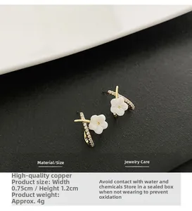Detailed view of flower stud earrings featuring gold base and white petals, 0.75x1.2cm size