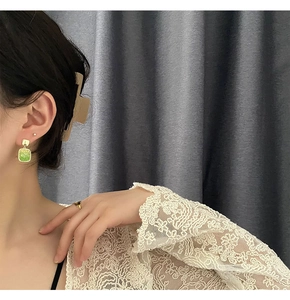 Close-up of elegant emerald green square drop earrings with retro gold-finish hooks