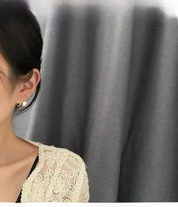 Detail of elegant gold hoop earrings with white flower charms worn by a female model