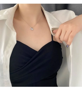 Detailed view of titanium steel necklace with B letter pendant and round logo charm
