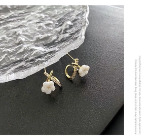 Detailed close-up of 18K gold plated flower earrings with sparkling zircon crystals