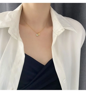 Detailed view of a gold-plated titanium steel necklace with a blue enamel letter B pendant