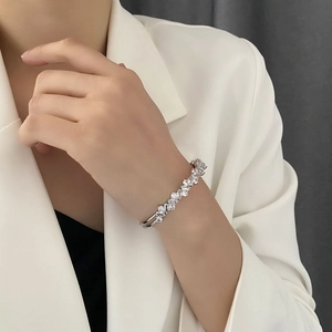Bracelet manchette argenté de style français avec zircon serti au poignet d'une femme