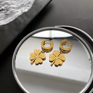 Elegant gold four-leaf clover hoop earrings in polished titanium steel with radial texture