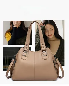 Macro detail of khaki litchi grain leather tote bag with metallic zipper and shoulder strap