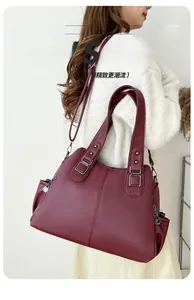 Detail of burgundy tote bag with litchi texture leather and dark gray metal hardware