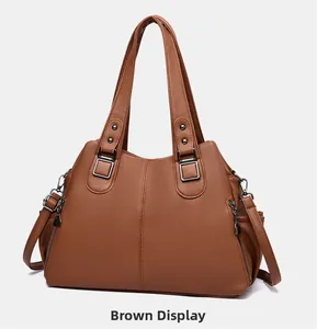 Detail view of brown pebbled leather tote with dual handles and side zipper hardware