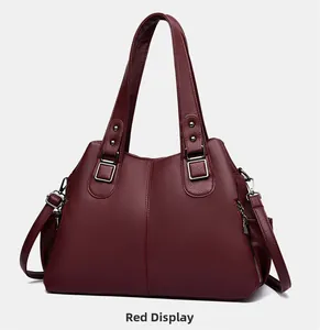 Detail view of red faux leather tote bag with lychee texture and silver zippers