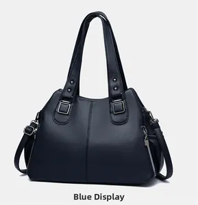 Detail view of navy blue pebbled leather tote bag with silver hardware and side zippers