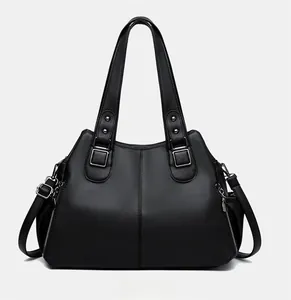 Detailed view of black pebbled leather tote bag with silver zippers and adjustable straps