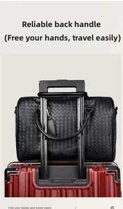 Detail der schwarzen gewebten Reisetasche mit Schlaufe für Koffergriffbefestigung