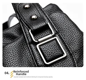 Close-up of litchi texture leather and reinforced silver hardware on a black tote bag