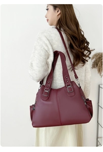Detail of burgundy large tote bag with lychee grain texture and dark silver hardware