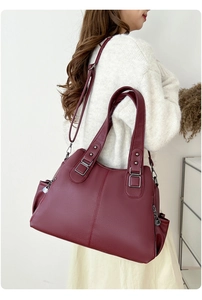 Close-up of burgundy pebbled leather tote bag with silver zippers and adjustable strap