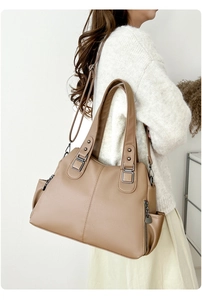 Detail of khaki tote bag showing pebble leather texture and side zipper pocket