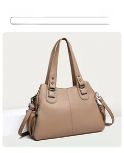 Detail of tan pebble leather tote with gunmetal hardware and side zipper accents