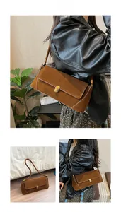 Dettaglio borsa baguette in pelle scamosciata marrone con fibbie in bronzo vintage