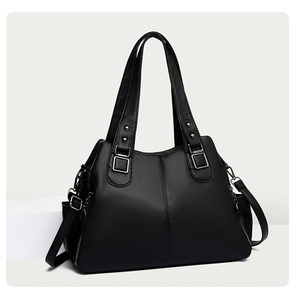 Detail of black pebbled leather tote bag with silver hardware, studs and zippers