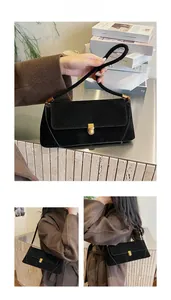 Dettaglio della borsa baguette in pelle scamosciata nera con chiusura in metallo dorato