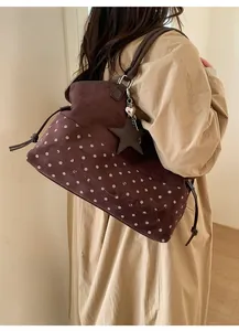 Detail of a large brown suede tote bag with white polka dots and star pendant