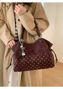 Detail of Moon Shark tote bag featuring dark brown suede and white polka dots textures