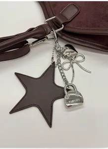 Detailed close-up of dark brown suede tote featuring stylish silver metal and star charms