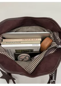 Interior detail of large tote bag showing laptop storage and striped zipper pocket